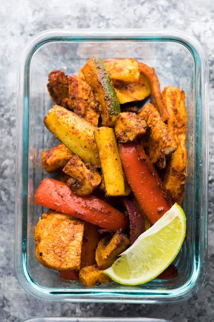 glass container, chicken fajitas, with zucchini and carrots, healthy meal prep, lime slice on the side