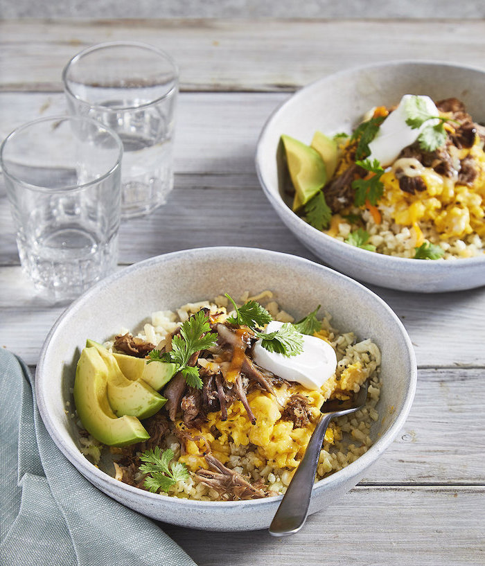 keto breakfast no eggs, mexican breakfast bowl, with avocado slices, sour cream on top, wooden table