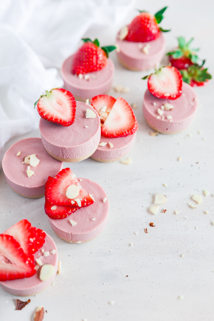 mini strawberry cheesecakes, strawberry slices on top, simple dessert recipes, white table