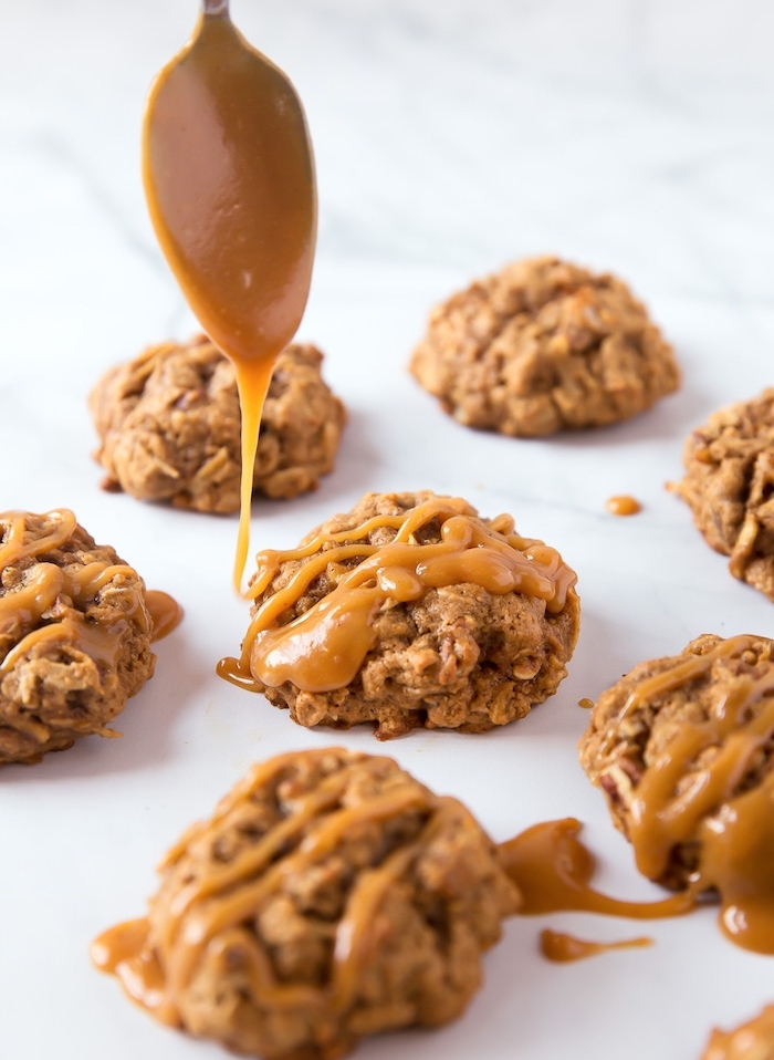 oatmeal cookies, caramel drizzle on top, tasty chocolate chip cookie, arranged on white table