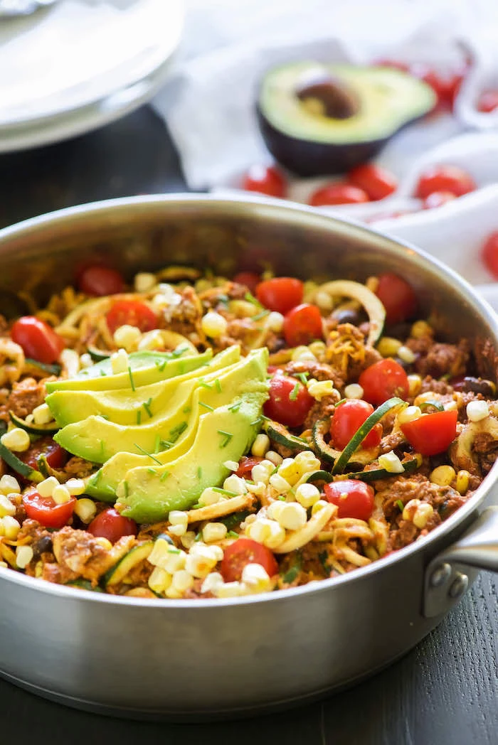 avocado slices, how to make zucchini noodles, cherry tomatoes, black beans, taco zoodles, in a skillet
