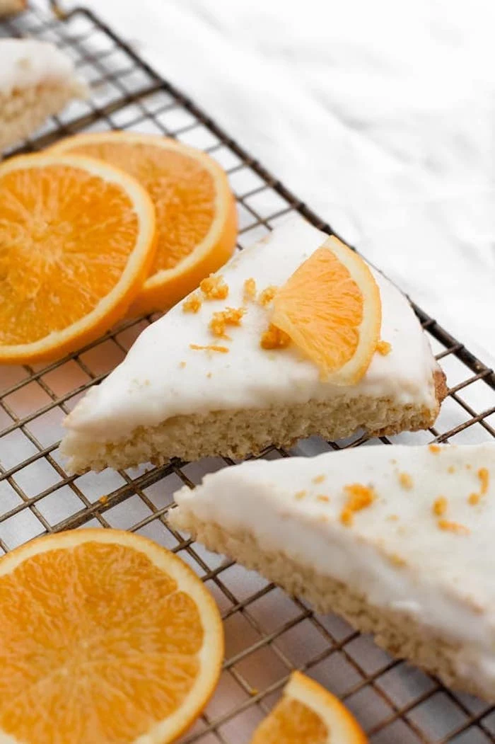 orange scones, white frosting, orange slices, orange flakes on top, keto breakfast recipes, arranged on metal rail
