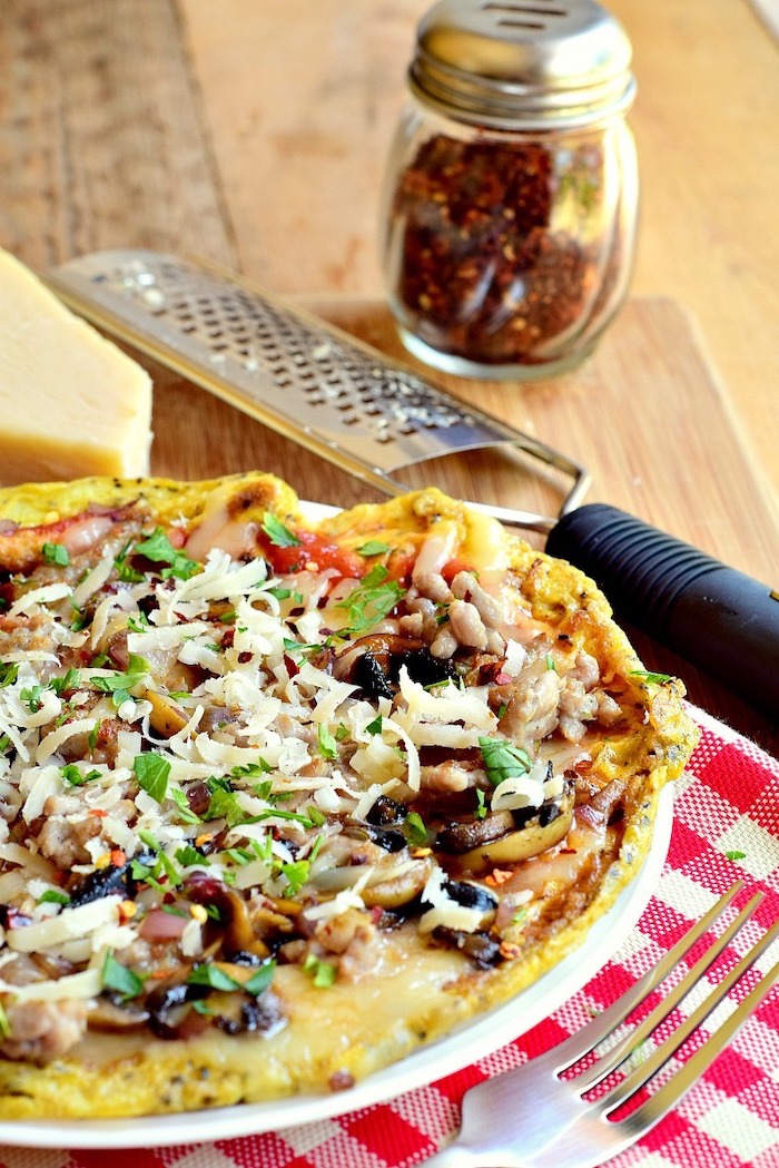 keto pizza, high protein low carb breakfast, with mushrooms and tomatoes, cheese on top, white plate