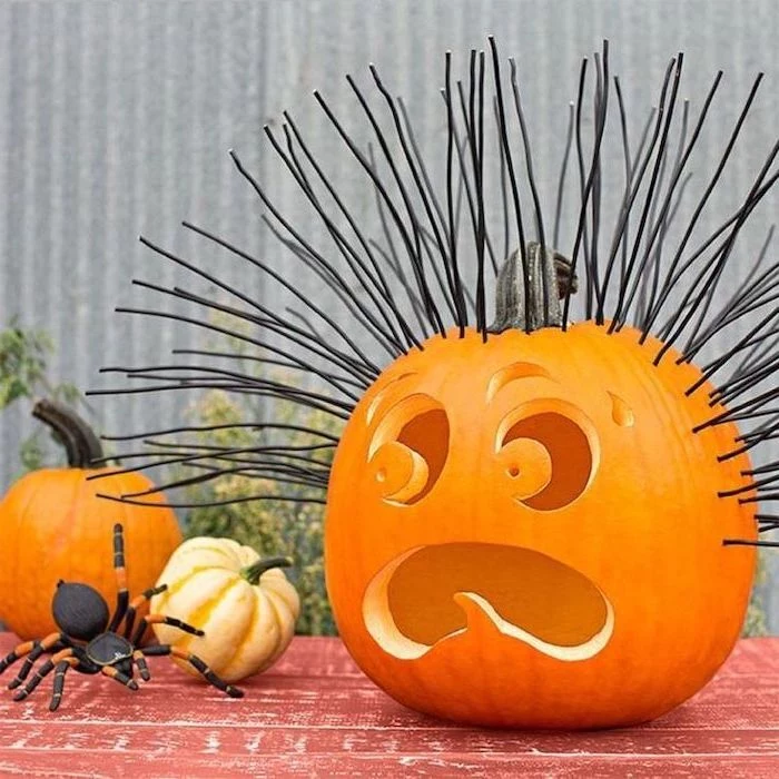 black wooden skewers, nailed to a pumpkin, unique pumpkin carving ideas, large plastic spider, red table