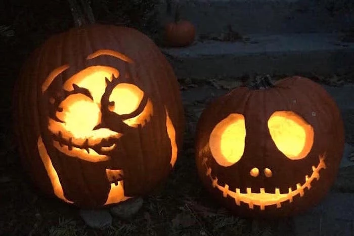 jack skellington and sally, nightmare before christmas inspired, funny pumpkin carving ideas, lit by candles