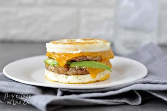 egg sandwich, with ground beef, cheese and avocado, low carb breakfast without eggs, white plate, grey cloth