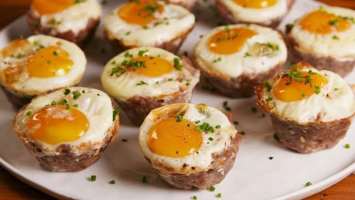 sausage and egg, cheese muffins, low carb breakfast without eggs, arranged on white plate, chives on top