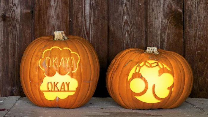 two pumpkins, with different carvings, funny pumpkin carving ideas, wooden background