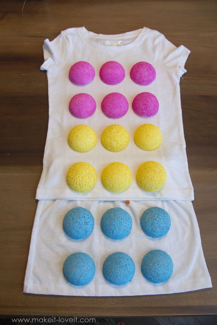 white shirt and skirt, painted styrofoam balls, glued to them, on a wooden table, baby costumes for boys