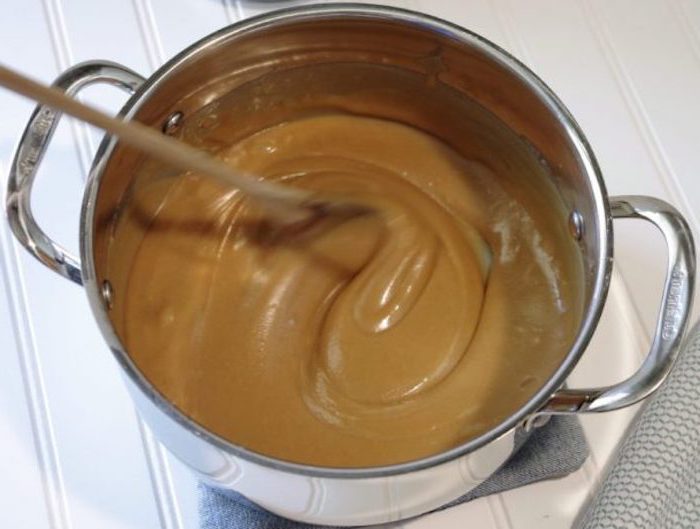 melted caramel, in a silver bowl, wooden spatula, quick and easy desserts, white wooden table