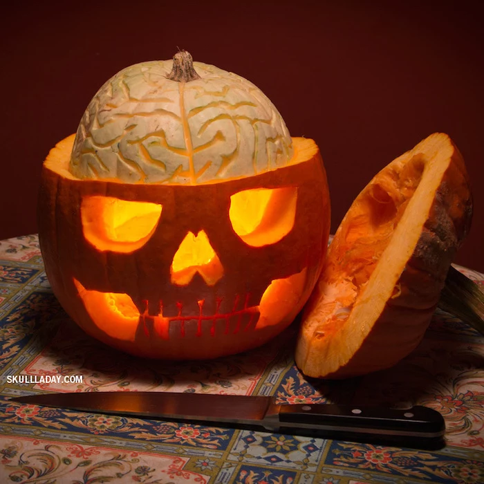 skull carved into a pumpkin, top removed, brains coming out, funny pumpkin carving ideas, colorful cloth