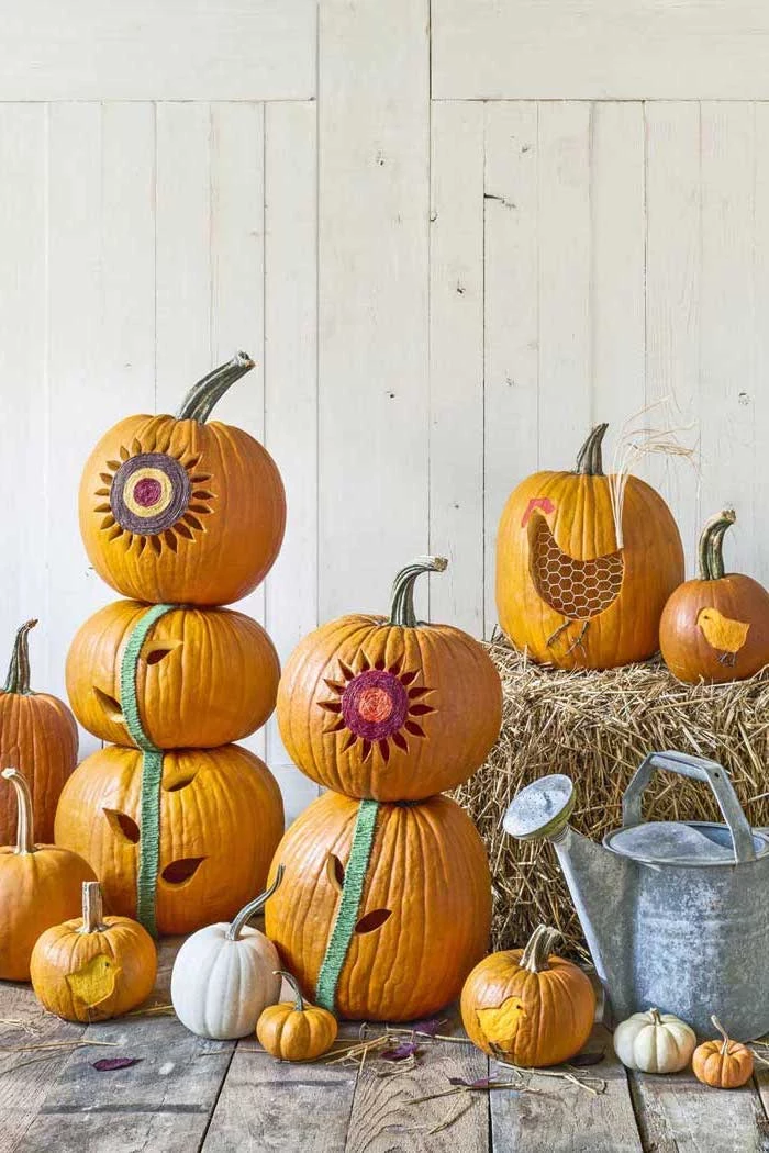 lots of pumpkins, stacked together, pumpkin carving designs, wooden background, hay stacks, metal bucket