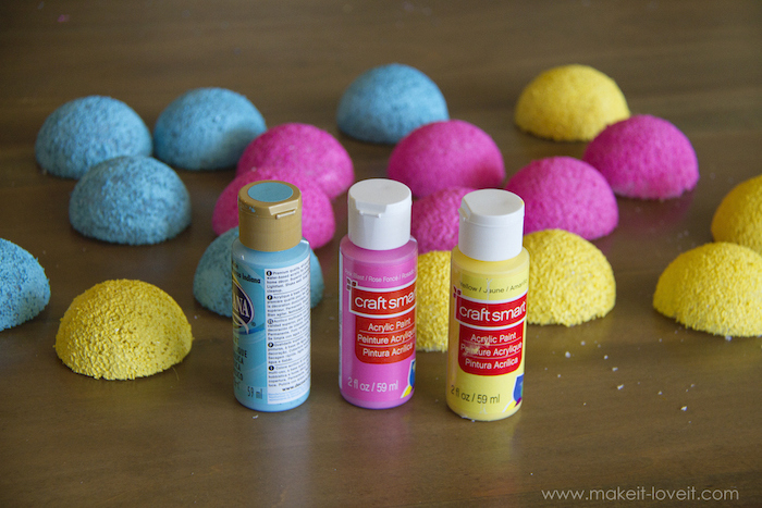 styrofoam balls, cut in half, baby costumes for boys, painted in blue yellow and pink, wooden table