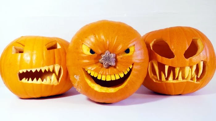 easy pumpkin carving ideas, three pumpkins, scary faces carved into them, white background