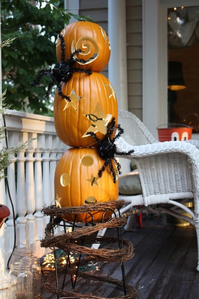 three pumpkins, stacked together, plastic spiders on them, easy pumpkin carving ideas, garden patio, white chair