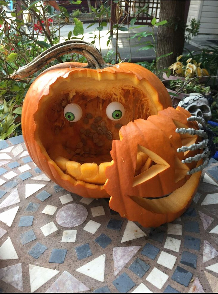 carved pumpkin, with plastic eyes, removable face, easy pumpkin carving ideas, tiled floor, skeleton hand
