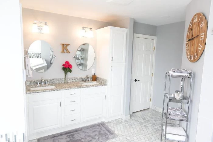 white walls, mosaic floor, tips for your bathroom remodel, two sinks, two mirrors, white vanity, wooden clock