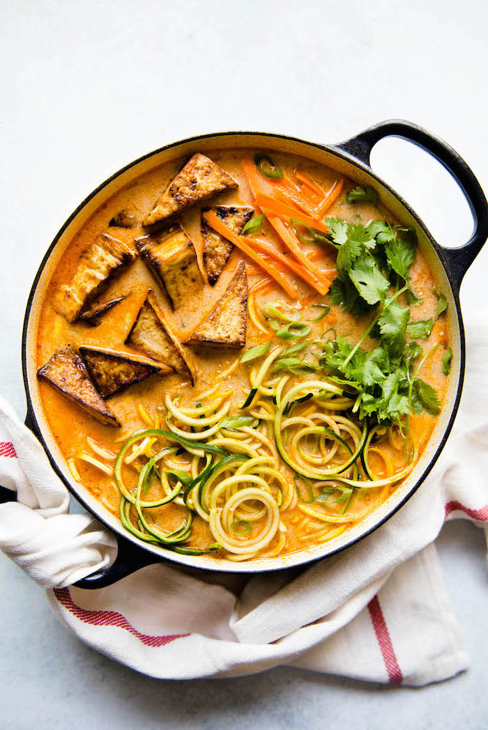 zoodles broth, with carrots and coconut, in a skillet, making zucchini noodles, white cloth