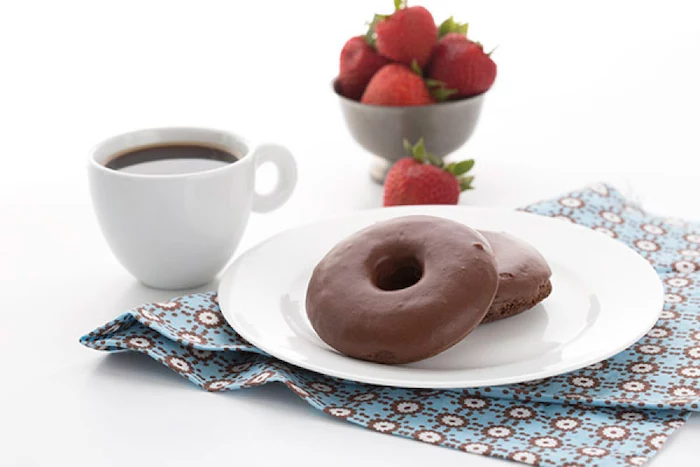 chocolate donuts, on white plate, keto breakfast ideas, coffee mug, strawberries in a metal bowl