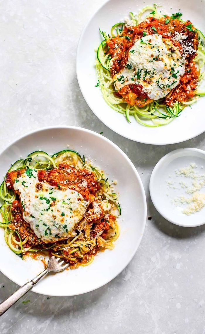 two white plates, chicken parmesan, zucchini noodles recipe, grated parmesan, granite countertop