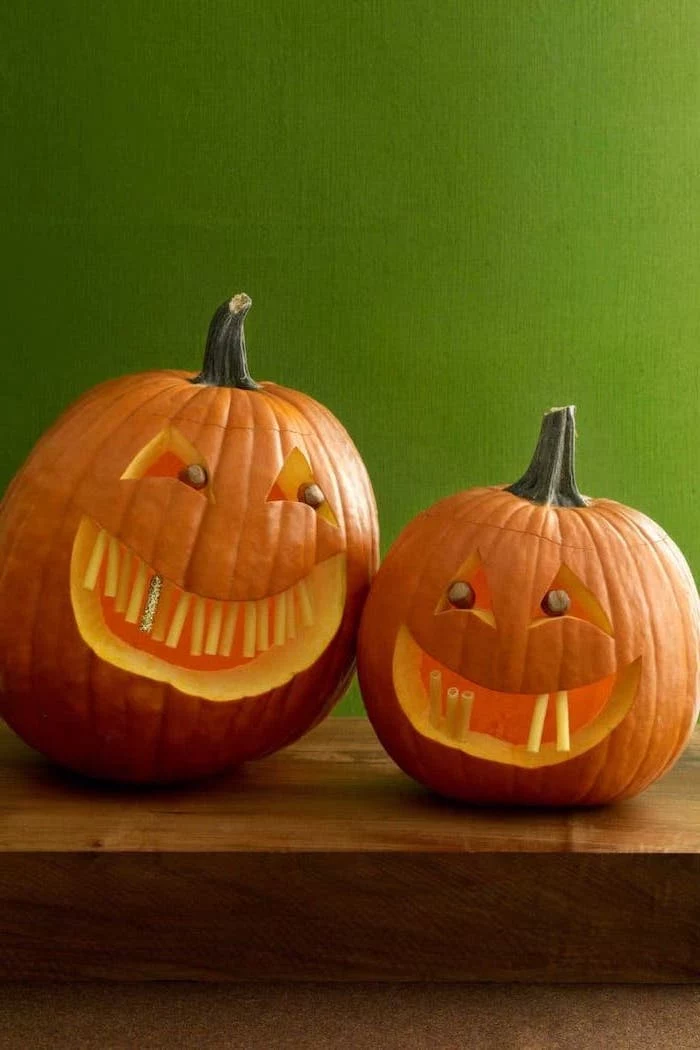 green wall, pumpkin carving patterns, two pumpkins, on a wooden table, pasta for teeth