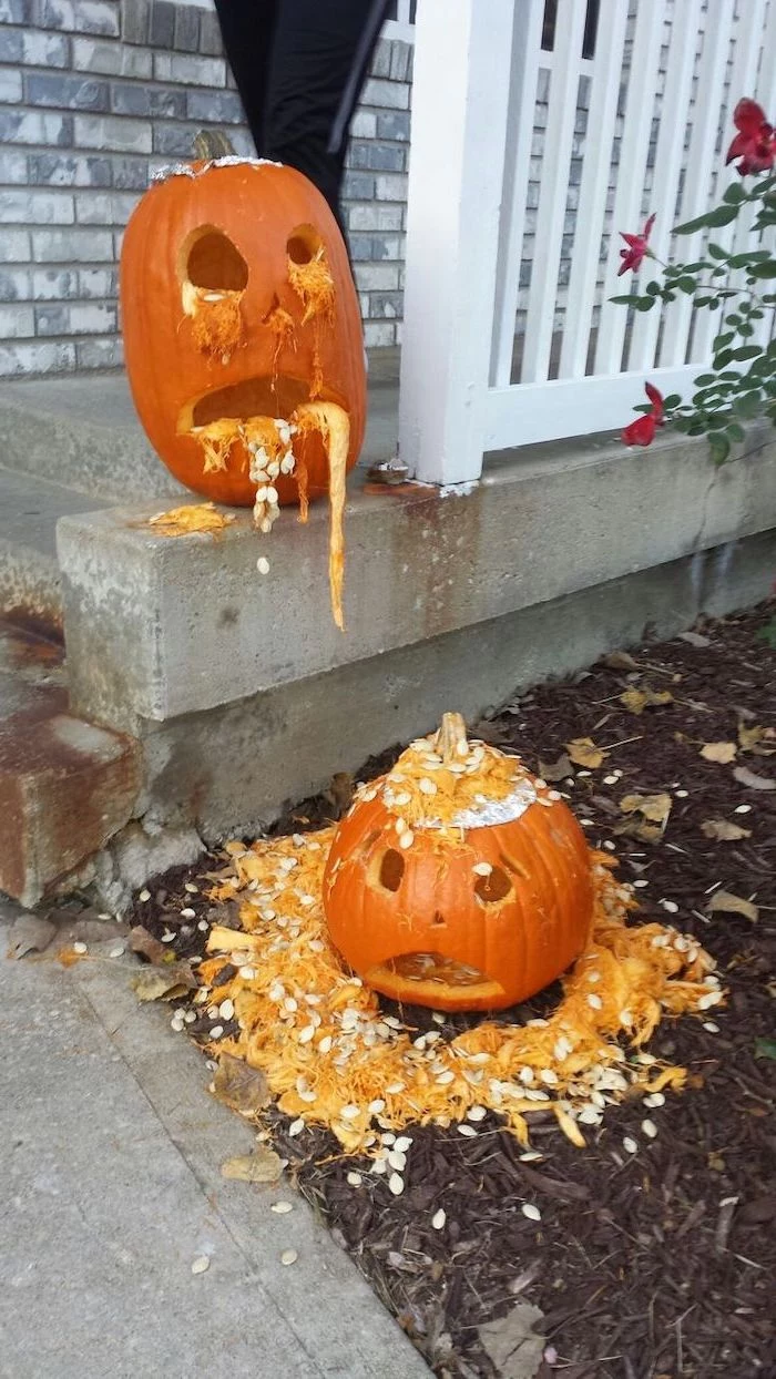 drunk pumpkin, vomiting on top of another, pumpkin carving patterns, white wooden fence, brick wall