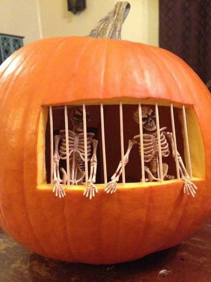 halloween pumpkin carvings, two skeletons, inside the pumpkin, jail bars, made of toothpicks