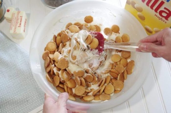 wafers and melted marshmallows, mixed together, inside a plastic bowl, quick and easy desserts, white wooden table