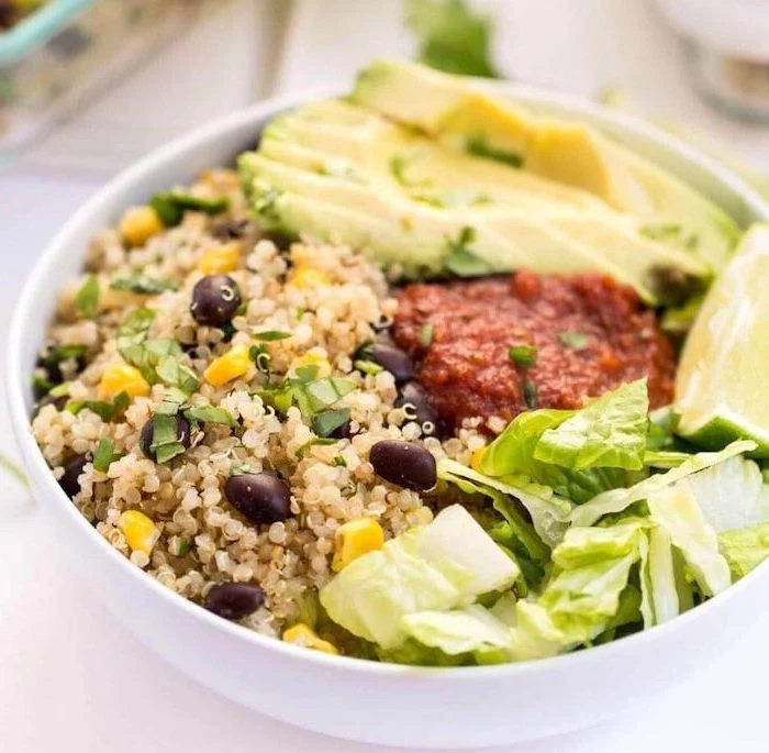 avocado slices, quinoa and corn, black beans, meal prep recipes weight loss, green salad, in a white bowl