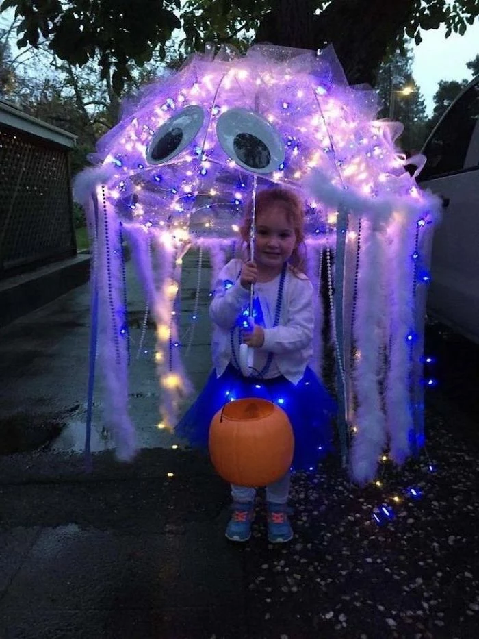 little girl, holding an umbrella, with white feathers, fairy lights, funny halloween costumes for kids, jellyfish costume