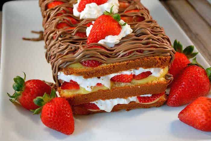 layered cake, with strawberries and cream, chocolate drizzle on top, easy dessert recipes with pictures, white plate