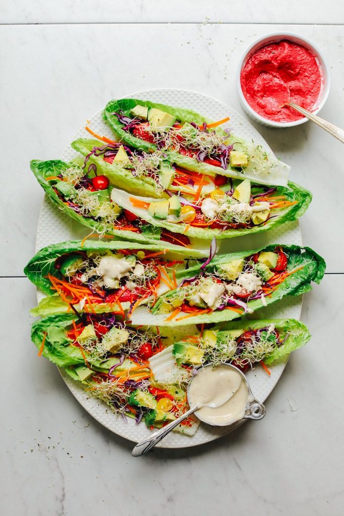 lettuce tacos, filled with vegetables, ground beef tacos, garlic sauce, salsa sauce, white plate, marble countertop