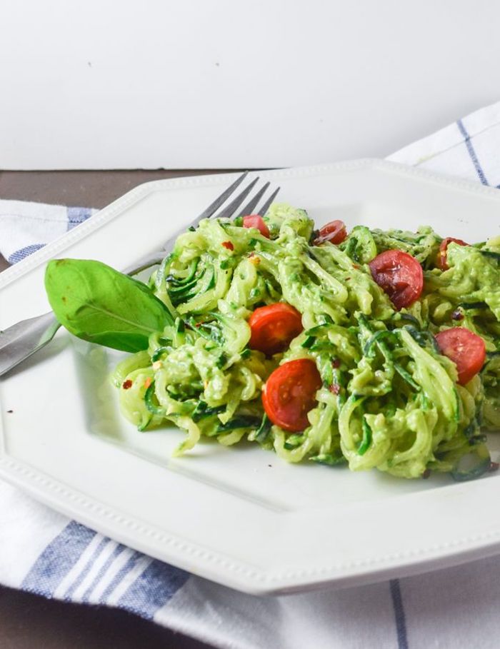zoodles with pesto, how to cook zucchini noodles, cherry tomatoes, white plate, white and blue table cloth