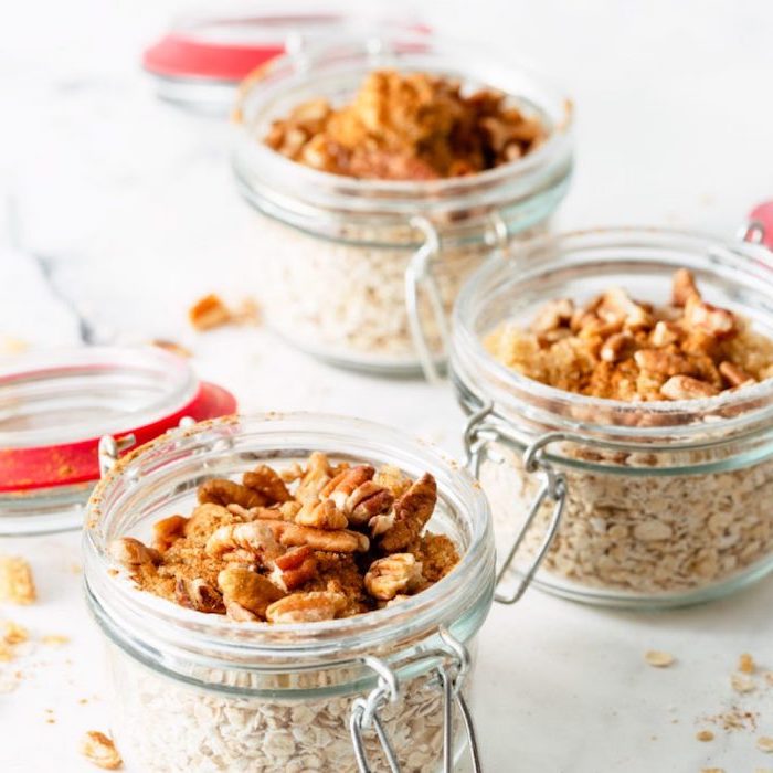 granola and yoghurt, inside mason jars, meal prep recipes weight loss, nuts and cinnamon on top, white table