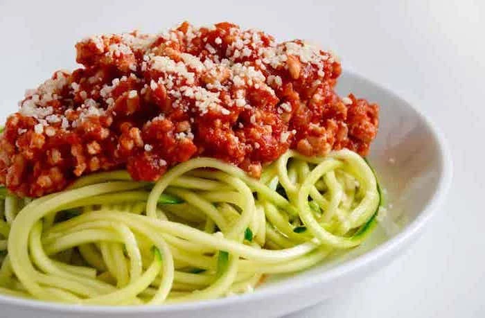 zucchini noodles, turkey bolognese, parmesan on top, what are zoodles, white plate, white background