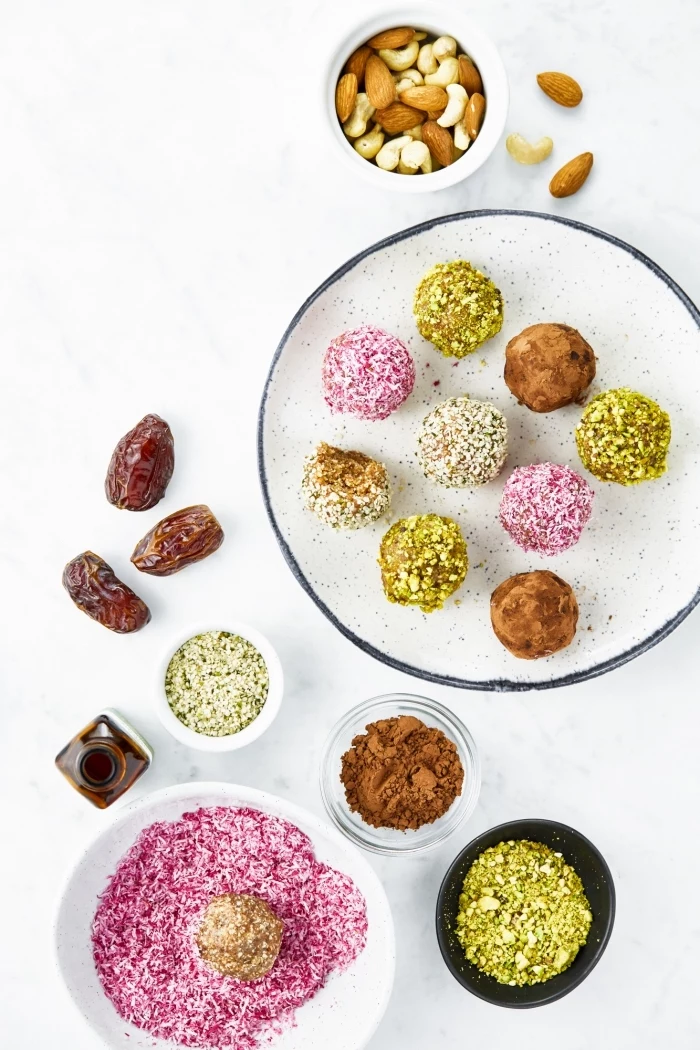 almonds and dates, cocoa and pistachio nuts, no bake energy bites, in bowls, white table