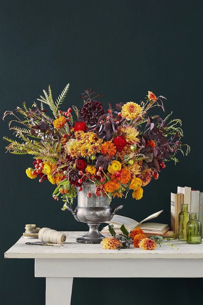 large bouquet, made of autumn flowers, in large silver vase, thanksgiving decorations, black background