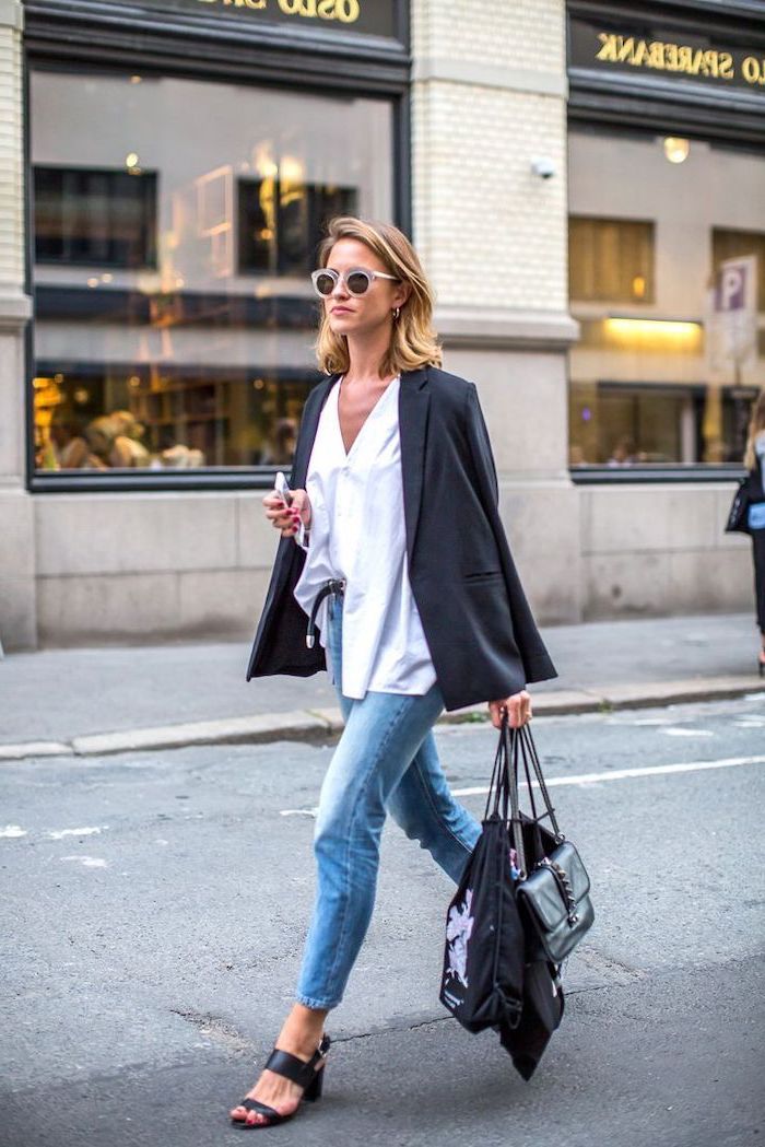 woman walking down the street, wearing jeans and white shirt, shoulder length hairstyles, blonde hair, holding bags