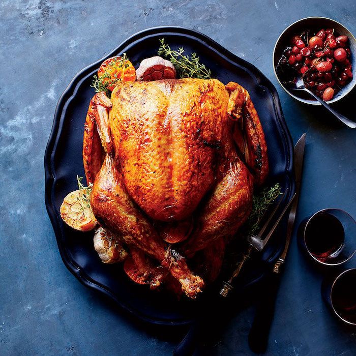 black plate, black granite table, how to bake a turkey, roasted turkey, fresh herbs, garlic on the side