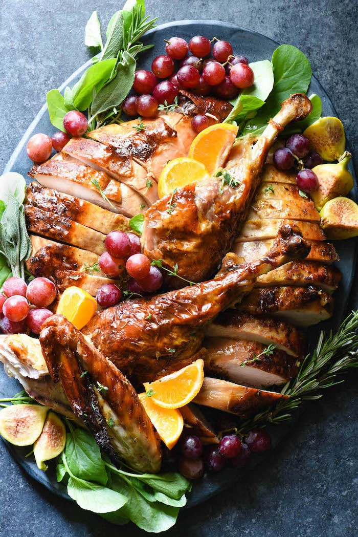carved turkey, grapes and dragon fruit, fresh herbs, lemon slices, on the side, how to bake a turkey