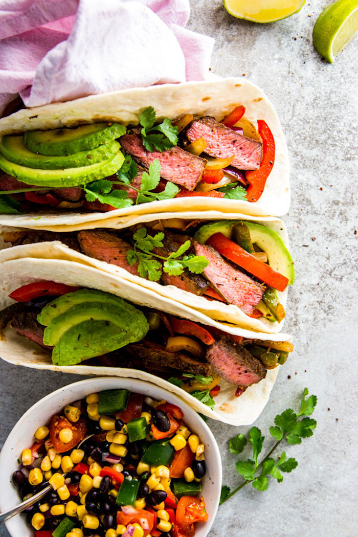 steak fajitas, weight loss diet, avocado slices, corn and peppers, cherry tomatoes, black beans, in a white bowl