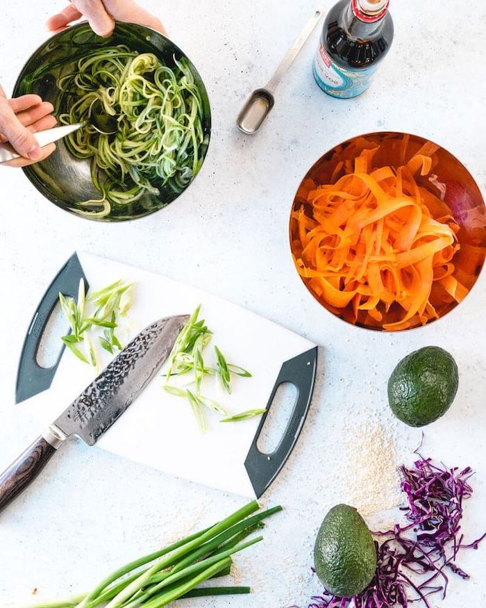 spiralised zucchini and carrots, in metal bowls, dinner ideas for tonight, white chopping board, white table, avocados and leeks