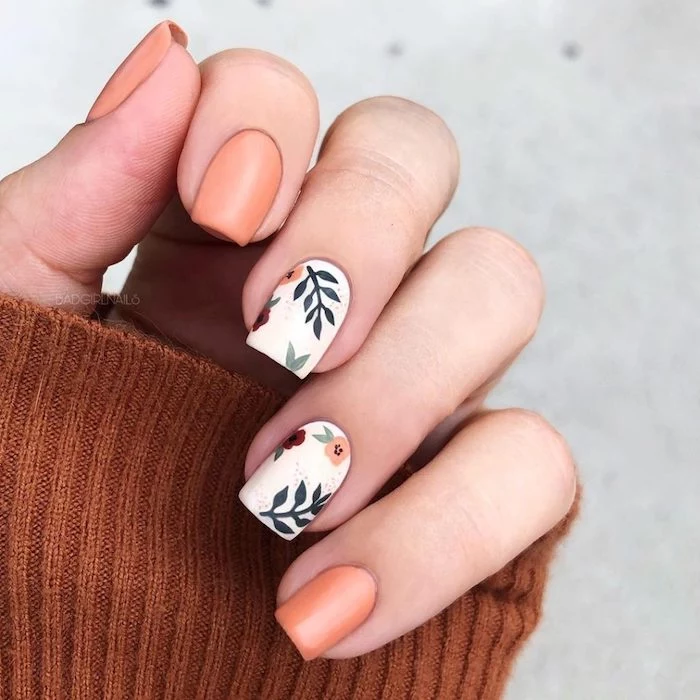 orange and white nail polish, fall nail designs, floral design, short square nails, brown sweater, white background