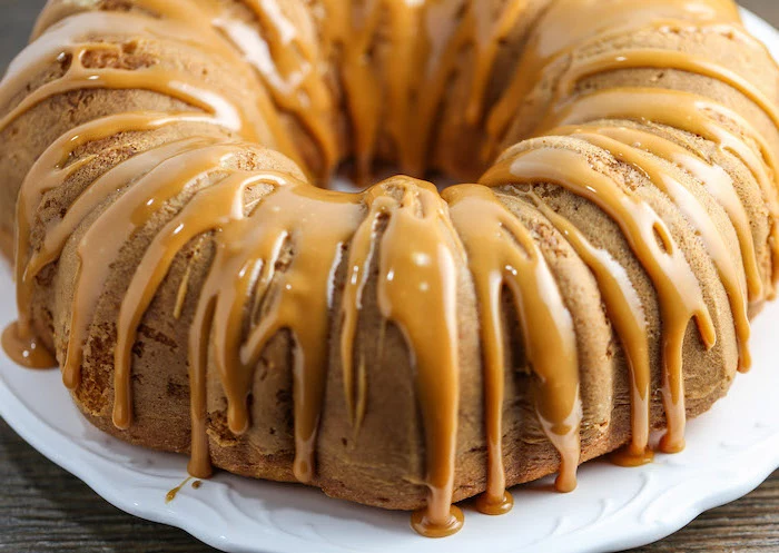 bundt cake, chocolate thanksgiving desserts, caramel drizzle on top, white plate, wooden table