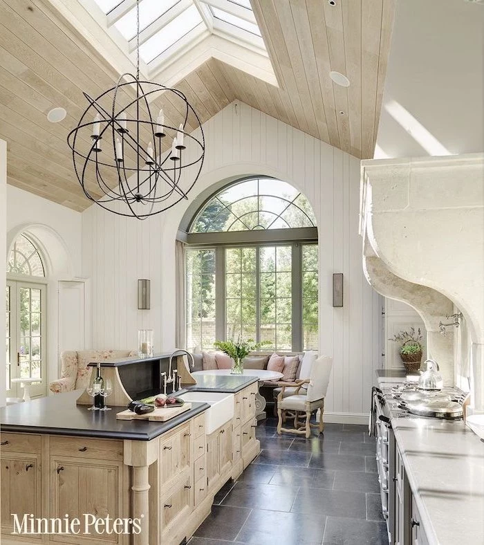 wooden ceiling with skylights, vaulted ceiling ideas, tiled floor, wooden kitchen island, white walls, rustic decor