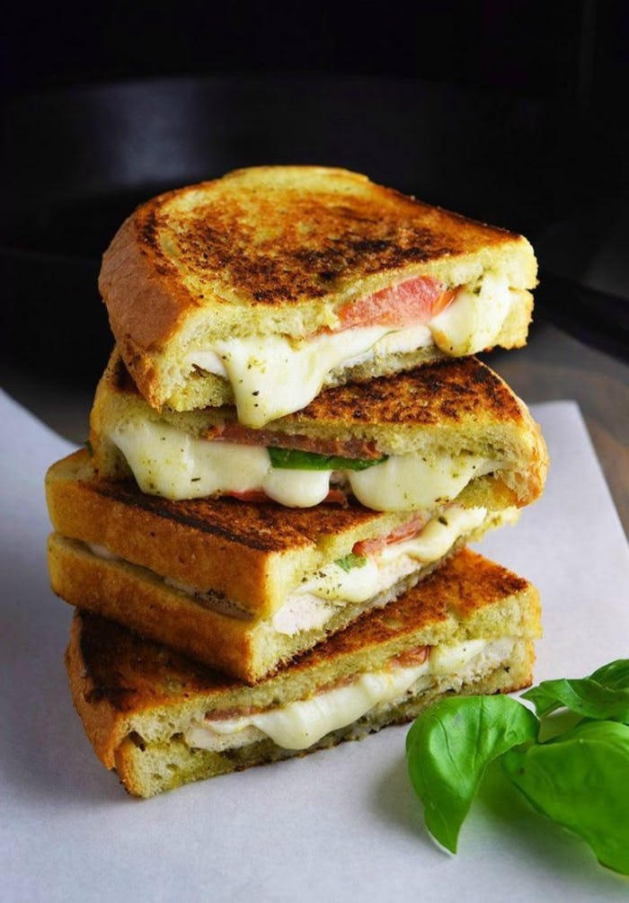 grilled cheese sandwich, chicken pesto panini, easy healthy dinner ideas, white plate, basil leaves on the side