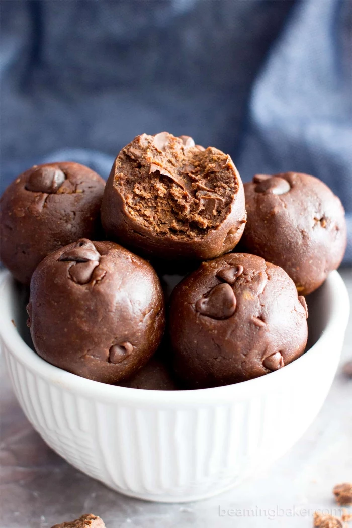 no bake protein balls, with chocolate chips, in a white bowl, blurred background
