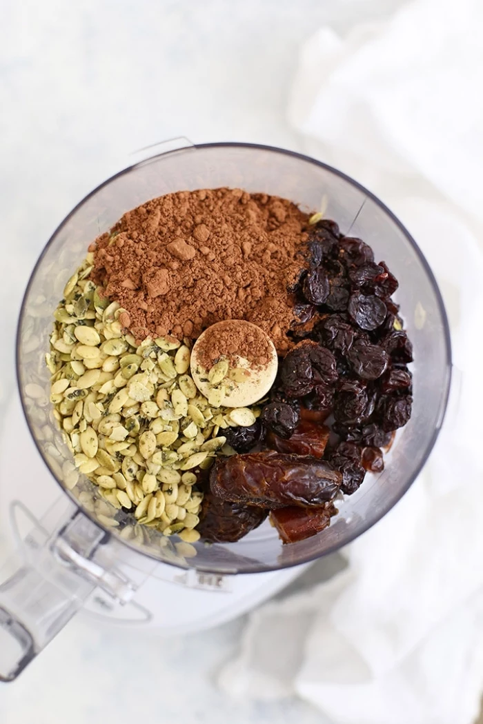 pistachio nuts, cocoa and dates, in a blender, energy bites, white background