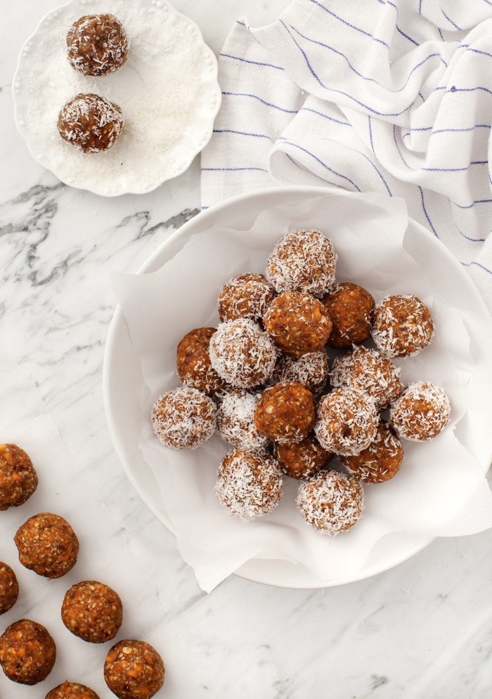 coconut flakes, in a white plate, peanut butter oatmeal balls, dipped in coconut flakes, white cloth