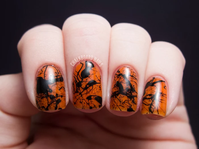 orange nail polish, black splashes, nail decorations, nail color ideas, black background, short squoval nails